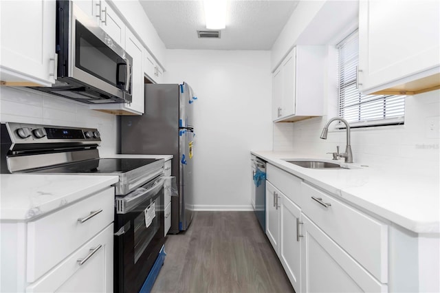 840 Center Ave Unit 80, Daytona Beach, FL 32117 - kitchen featuring appliances with stainless steel finishes, tasteful backsplash, white cabinetry, and dark wood-style flooring