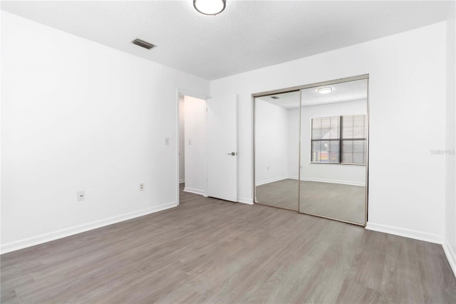 840 Center Ave Unit 80, Daytona Beach, FL 32117 - unfurnished bedroom featuring wood finished floors, a closet, and a textured ceiling
