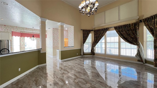 934 Westpark Dr, Celebration, FL 34747 - unfurnished dining area with a chandelier, marble tiled flooring, plenty of natural light, and ornate columns