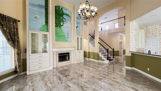 934 Westpark Dr, Celebration, FL 34747 - unfurnished living room with stairs, a chandelier, marble finish flooring, arched walkways, and a high ceiling