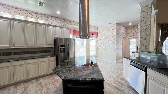934 Westpark Dr, Celebration, FL 34747 - kitchen featuring stainless steel appliances, island range hood, wallpapered walls, a textured ceiling, and dark stone counters