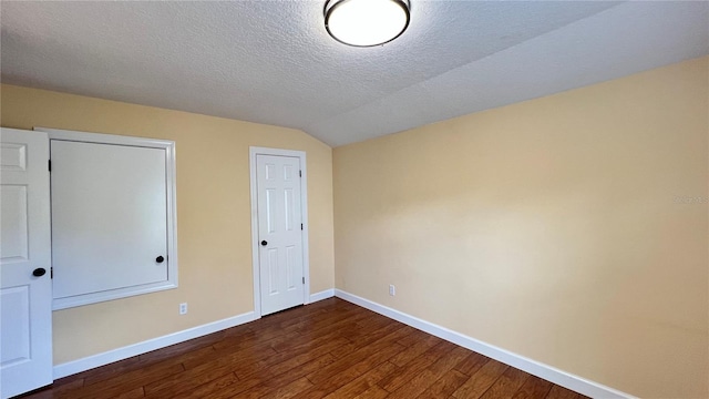 934 Westpark Dr, Celebration, FL 34747 - unfurnished bedroom with dark wood-style floors, a textured ceiling, and vaulted ceiling