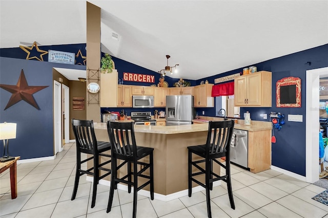 4828 Jeanette Ct, Saint Cloud, FL 34771 - kitchen featuring stainless steel appliances, light brown cabinetry, light countertops, a kitchen breakfast bar, and light tile patterned floors