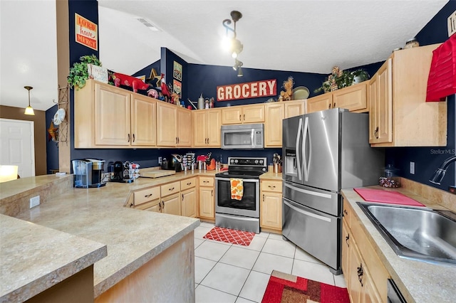 4828 Jeanette Ct, Saint Cloud, FL 34771 - kitchen with appliances with stainless steel finishes, light brown cabinetry, light countertops, light tile patterned floors, and vaulted ceiling