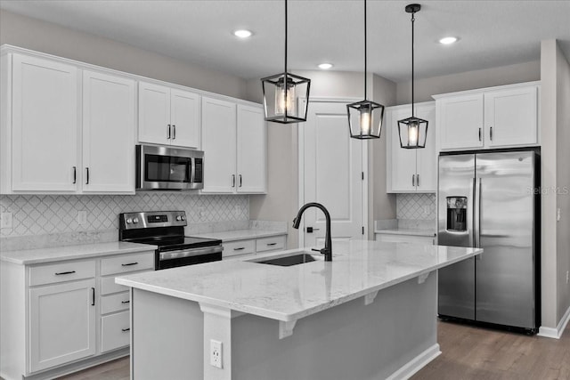 1717 Hilltop Dr, Dundee, FL 33838 - kitchen featuring stainless steel appliances, wood finished floors, white cabinetry, pendant lighting, and recessed lighting
