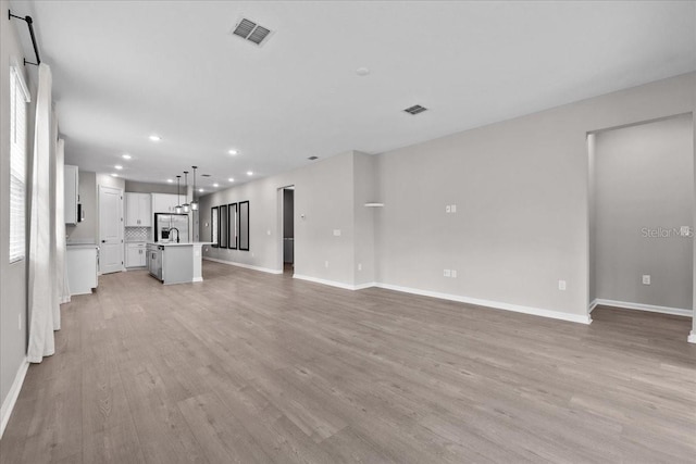 1717 Hilltop Dr, Dundee, FL 33838 - unfurnished living room with light wood finished floors and recessed lighting