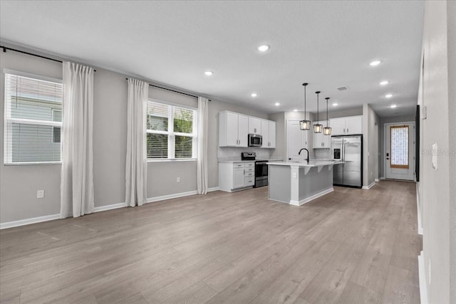 1717 Hilltop Dr, Dundee, FL 33838 - kitchen featuring stainless steel appliances, light countertops, a breakfast bar area, light wood-type flooring, and recessed lighting
