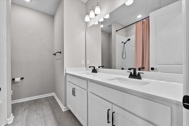 1717 Hilltop Dr, Dundee, FL 33838 - bathroom with wood finished floors, double vanity, and a tile shower