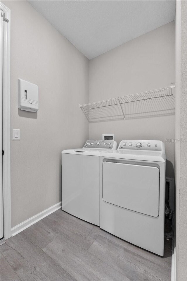 1717 Hilltop Dr, Dundee, FL 33838 - washroom featuring washer and clothes dryer and wood finished floors
