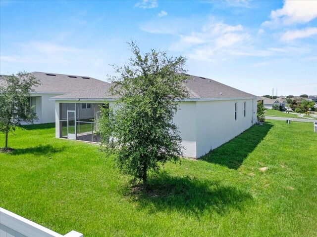 1717 Hilltop Dr, Dundee, FL 33838 - back of house featuring a lawn, a sunroom, and roof with shingles