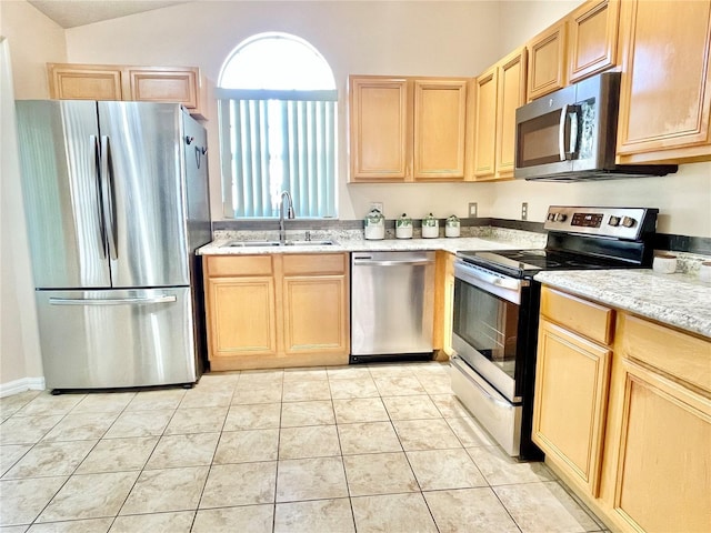 162 Seneca Point Trl, Kissimmee, FL 34746 - kitchen featuring stainless steel appliances, light brown cabinets, lofted ceiling, light stone counters, and light tile patterned floors