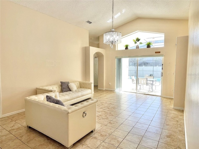 162 Seneca Point Trl, Kissimmee, FL 34746 - living area with arched walkways, high vaulted ceiling, a chandelier, light tile patterned floors, and a textured ceiling
