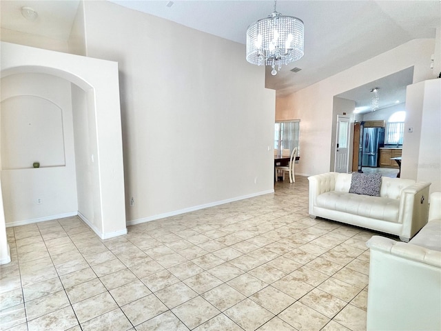 162 Seneca Point Trl, Kissimmee, FL 34746 - living room featuring a chandelier, arched walkways, vaulted ceiling, and light tile patterned floors