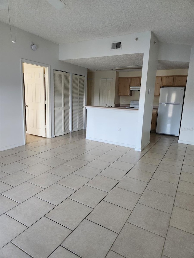 3502 Windy Walk Way Unit 2-208, Orlando, FL 32837 - unfurnished living room featuring a textured ceiling and light tile patterned floors