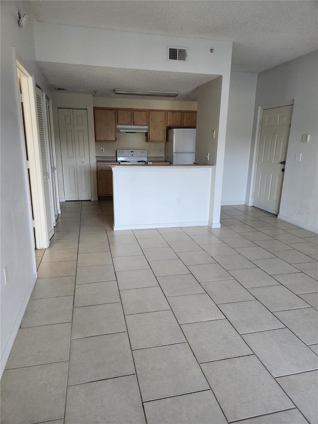 3502 Windy Walk Way Unit 2-208, Orlando, FL 32837 - kitchen featuring white appliances, under cabinet range hood, a peninsula, a textured ceiling, and light tile patterned floors