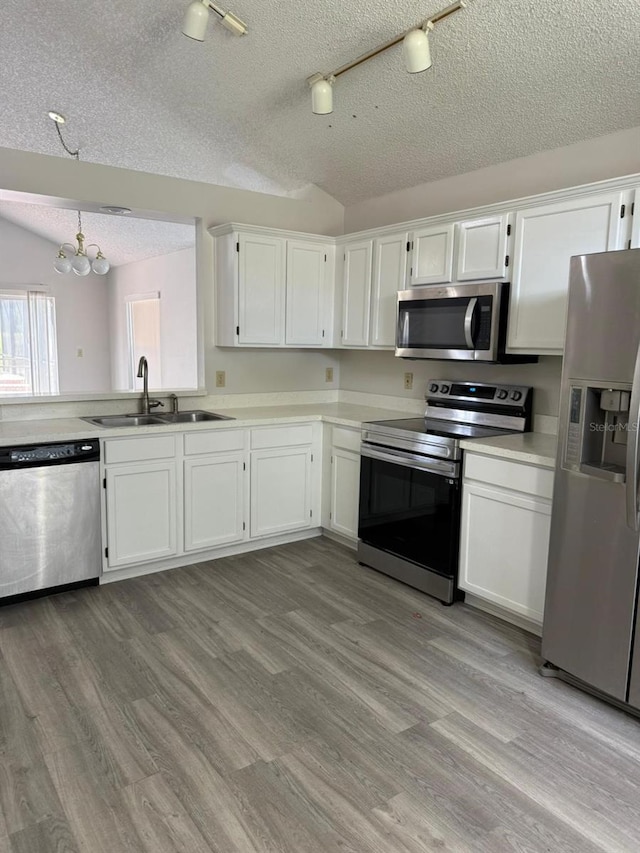 2833 Falling Tree Cir, Orlando, FL 32837 - kitchen with stainless steel appliances, a textured ceiling, a chandelier, white cabinetry, and light countertops