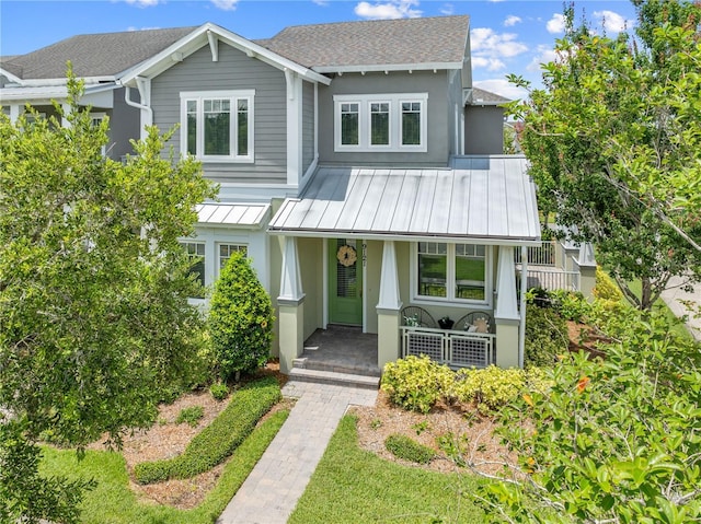 9121 Laureate Blvd, Orlando, FL 32827 - view of front of property featuring a porch, a standing seam roof, a metal roof, roof with shingles, and stucco siding
