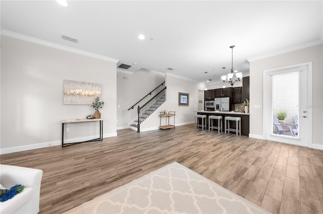 9121 Laureate Blvd, Orlando, FL 32827 - living area featuring a chandelier, ornamental molding, light wood-style floors, stairs, and recessed lighting
