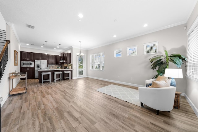 9121 Laureate Blvd, Orlando, FL 32827 - living area featuring stairway, a chandelier, light wood finished floors, recessed lighting, and plenty of natural light
