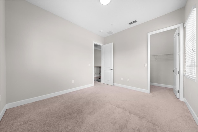 9121 Laureate Blvd, Orlando, FL 32827 - unfurnished bedroom with light colored carpet, multiple windows, and a spacious closet