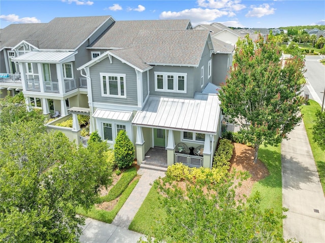 9121 Laureate Blvd, Orlando, FL 32827 - view of property featuring a porch, a standing seam roof, roof with shingles, a metal roof, and a residential view