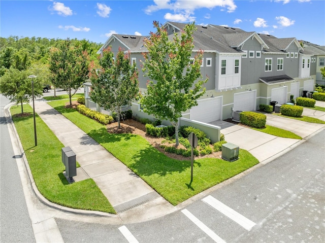 9121 Laureate Blvd, Orlando, FL 32827 - view of front of house with a residential view, concrete driveway, an attached garage, stucco siding, and a front lawn