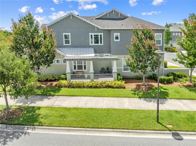 9121 Laureate Blvd, Orlando, FL 32827 - view of front facade featuring stucco siding, a front lawn, a shingled roof, and a metal roof