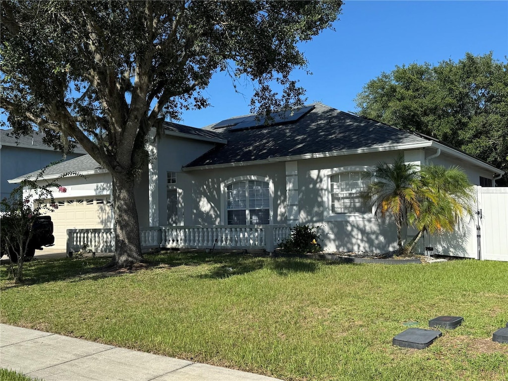 478 Acacia Tree Way, Kissimmee, FL 34758 - view of front of property featuring a garage, roof mounted solar panels, and a shingled roof
