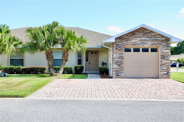 1749 Christina Lee Ln, Saint Cloud, FL 34769 - view of front of property with an attached garage, stucco siding, decorative driveway, a front lawn, and stone siding