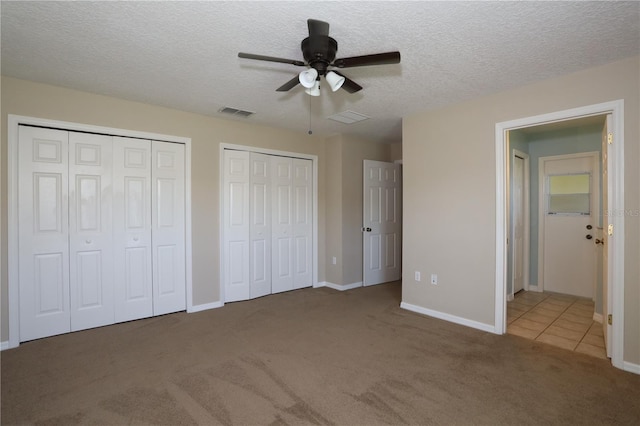 1749 Christina Lee Ln, Saint Cloud, FL 34769 - unfurnished bedroom featuring multiple closets, carpet flooring, a textured ceiling, and a ceiling fan