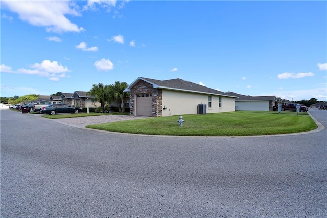 1749 Christina Lee Ln, Saint Cloud, FL 34769 - view of home's exterior featuring stone siding, a yard, driveway, stucco siding, and an attached garage