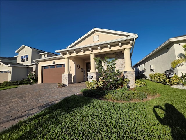 2853 Willowseed Ln, Saint Cloud, FL 34772 - view of front of home with stucco siding, a garage, decorative driveway, a front lawn, and stone siding