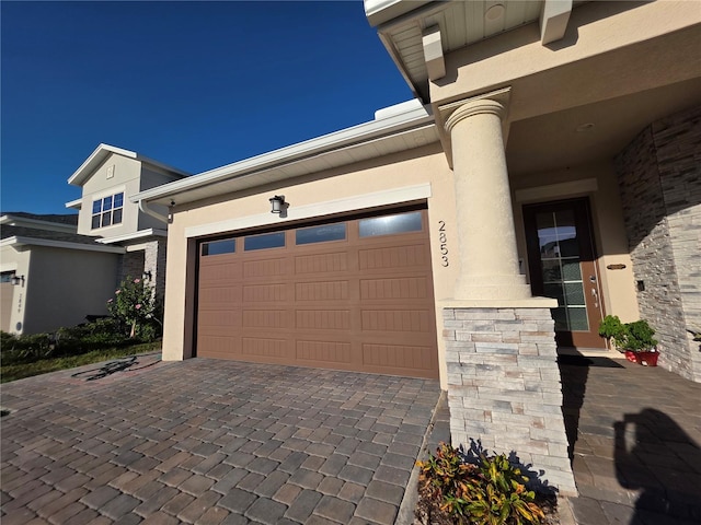2853 Willowseed Ln, Saint Cloud, FL 34772 - view of front facade featuring stucco siding, stone siding, decorative driveway, and an attached garage