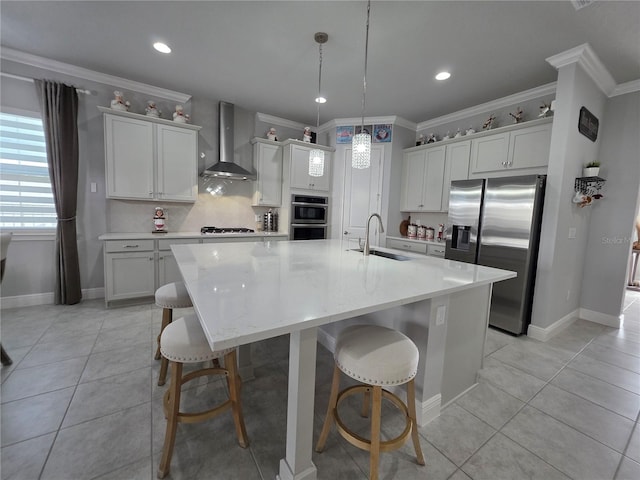 2853 Willowseed Ln, Saint Cloud, FL 34772 - kitchen with wall chimney range hood, stainless steel appliances, a spacious island, a breakfast bar area, and ornamental molding