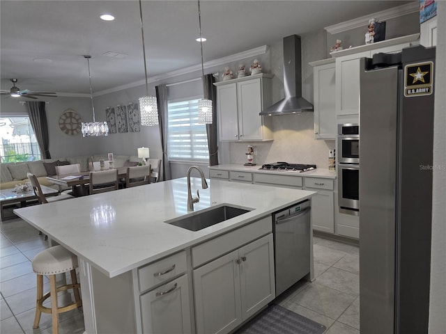 2853 Willowseed Ln, Saint Cloud, FL 34772 - kitchen with wall chimney exhaust hood, stainless steel appliances, open floor plan, ornamental molding, and an island with sink