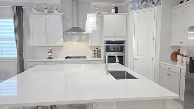 2853 Willowseed Ln, Saint Cloud, FL 34772 - kitchen with double oven, wall chimney range hood, gas stovetop, backsplash, and a spacious island