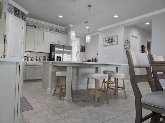 2853 Willowseed Ln, Saint Cloud, FL 34772 - kitchen with stainless steel fridge with ice dispenser, a breakfast bar, tasteful backsplash, ornamental molding, and recessed lighting
