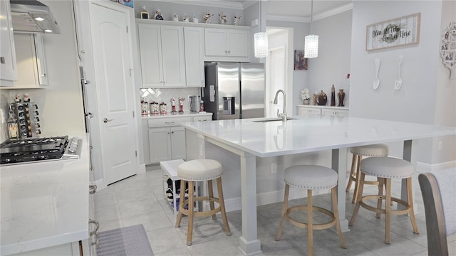 2853 Willowseed Ln, Saint Cloud, FL 34772 - kitchen with stainless steel appliances, range hood, crown molding, tasteful backsplash, and a kitchen breakfast bar