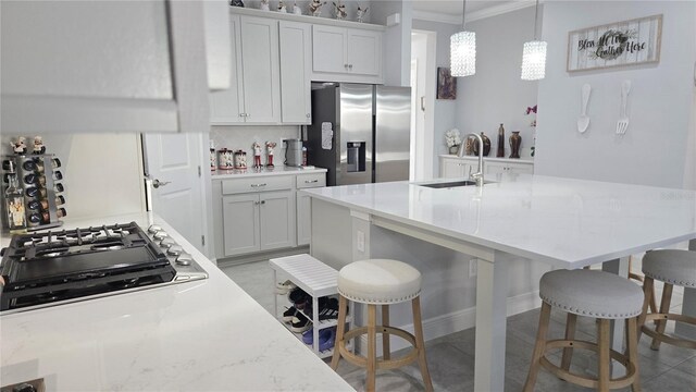 2853 Willowseed Ln, Saint Cloud, FL 34772 - kitchen featuring stainless steel appliances, a kitchen breakfast bar, crown molding, white cabinets, and decorative light fixtures