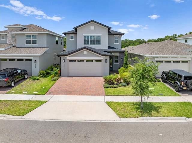 3204 Oxbow Ct, Saint Cloud, FL 34773 - traditional-style house featuring decorative driveway, stucco siding, an attached garage, and a front yard