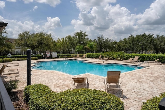 7621 Sutherton Ln, Windermere, FL 34786 - community pool featuring a patio and view of wooded area