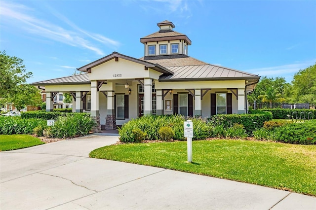 7621 Sutherton Ln, Windermere, FL 34786 - view of front of house featuring a standing seam roof, stucco siding, a metal roof, and covered porch