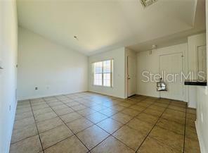 851 Adour Dr Unit A-B, Kissimmee, FL 34759 - tiled empty room featuring lofted ceiling