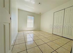 851 Adour Dr Unit A-B, Kissimmee, FL 34759 - unfurnished bedroom featuring tile patterned floors and a closet