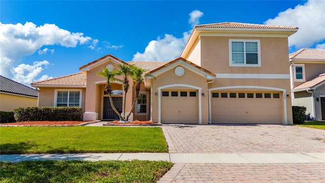 1950 Windward Oaks Ct, Kissimmee, FL 34746 - view of front of property featuring a tile roof, stucco siding, a front lawn, decorative driveway, and a garage