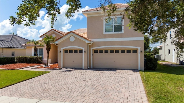 1950 Windward Oaks Ct, Kissimmee, FL 34746 - view of front facade featuring a tiled roof, decorative driveway, a front yard, and stucco siding