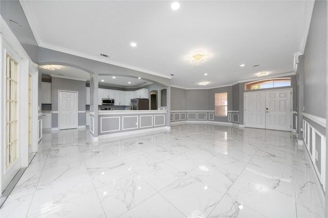 1950 Windward Oaks Ct, Kissimmee, FL 34746 - unfurnished living room with ornamental molding, a decorative wall, arched walkways, recessed lighting, and a wainscoted wall