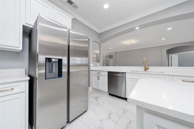 1950 Windward Oaks Ct, Kissimmee, FL 34746 - kitchen featuring appliances with stainless steel finishes, ornamental molding, recessed lighting, light marble finish floors, and arched walkways