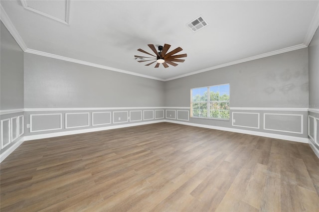 1950 Windward Oaks Ct, Kissimmee, FL 34746 - empty room with ceiling fan, wood finished floors, crown molding, a decorative wall, and wainscoting
