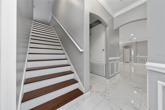 1950 Windward Oaks Ct, Kissimmee, FL 34746 - stairs featuring crown molding, marble finish floors, wainscoting, arched walkways, and a decorative wall